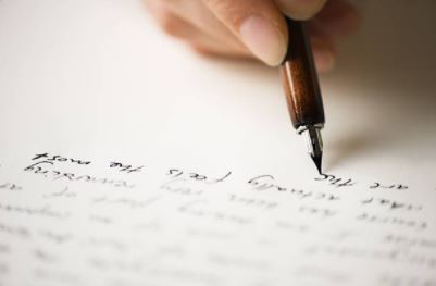 On voit un élève rédiger le commentaire de texte sur une page blanche.